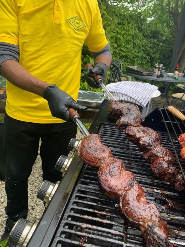 Brazilian churrasco barbecue with picanha steak, cheese, and chorizo grilling over charcoal